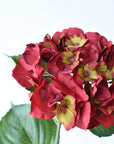 Red and green faux hydrangea florets in detail, poly silk texture