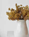 Three faux beige sedum bundles arranged together in a vessel