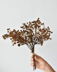 Hand holding a 13.5-inch faux dried brown baby's breath bundle
