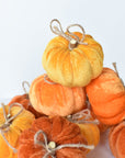 Velvet wrapped foam pumpkin with a twig stem and twine bow