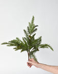 Close-up of faux pine needles and small pine cones on a wired bush