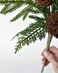 Artificial cedar and pine needles on a mixed winter greenery bush