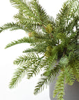 Two faux pine bushes with pinecones filling one pot