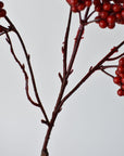 Weather proof faux red berry spray from the side showing its airy shape