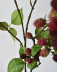 Detail of purple and mauve faux raspberries clustered along a wired branch