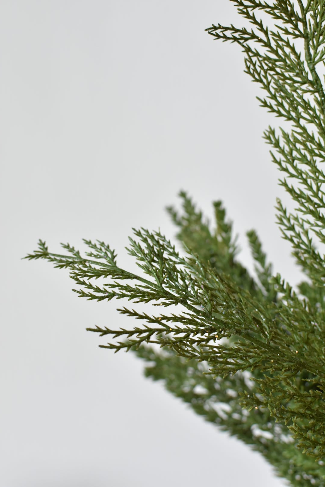 Close-up of faux cedar foliage showing fine clear glitter catching the light