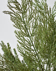 Artificial frosted cedar bundle from the side with its wired stems fanned open