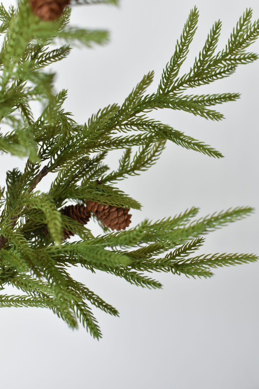 Artificial Norfolk pine stem showing soft green needles and wired branches