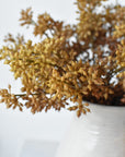 Close-up of faux beige sedum stems arranged in a vase