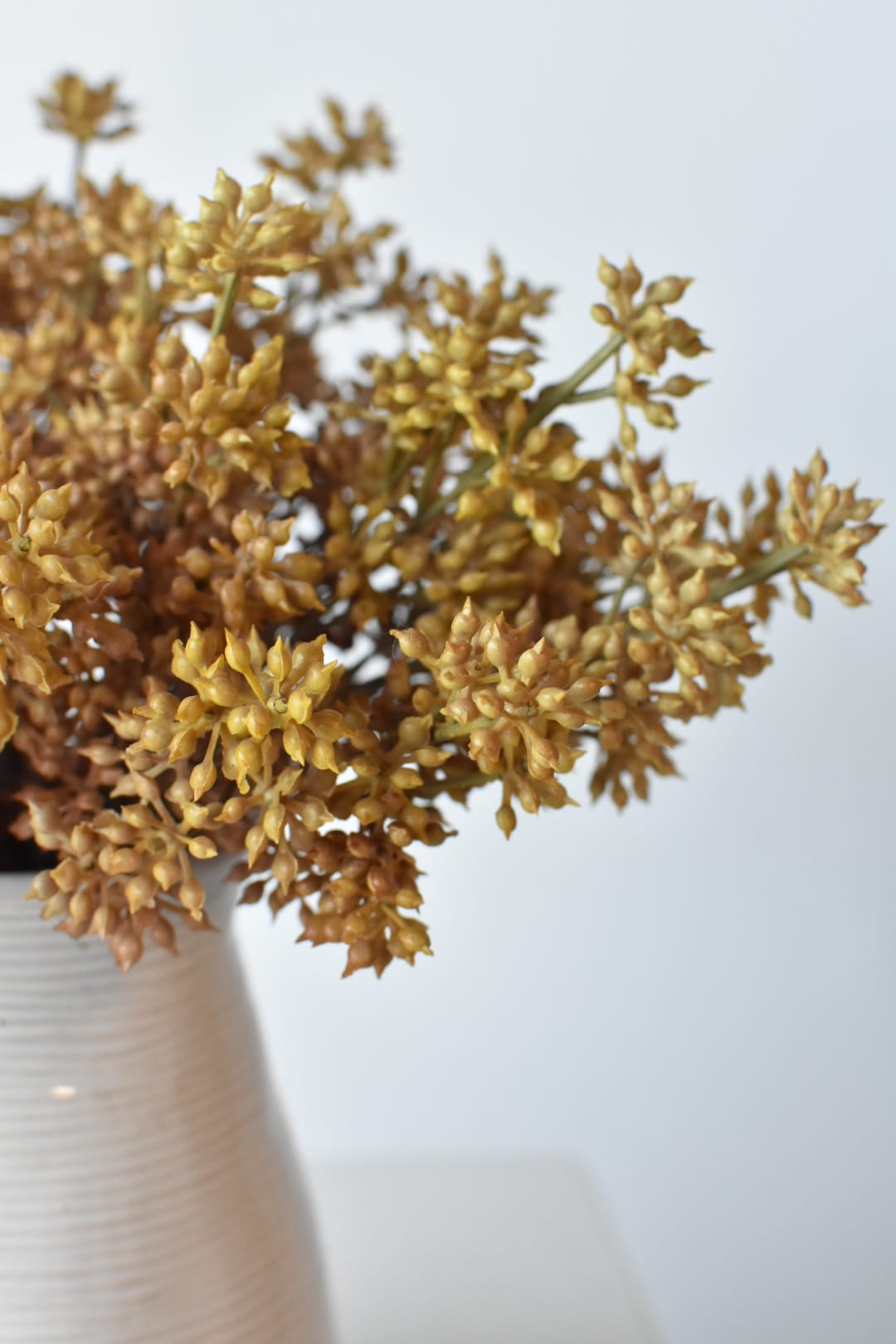 Faux beige sedum bundles in a vase showing depth of beige color