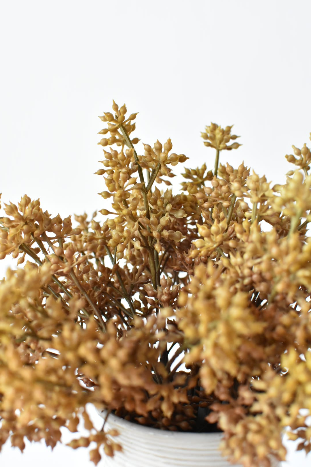 Close view of three faux beige sedum bundles mounded in a vase