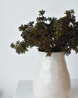 Faux dark brown and green sedum bundles arranged in a vessel