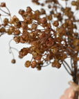 Faux brown gypsophila bundle held up showing its loose, airy shape