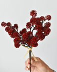 Hand holding an 11-inch faux red sedum stem bundle