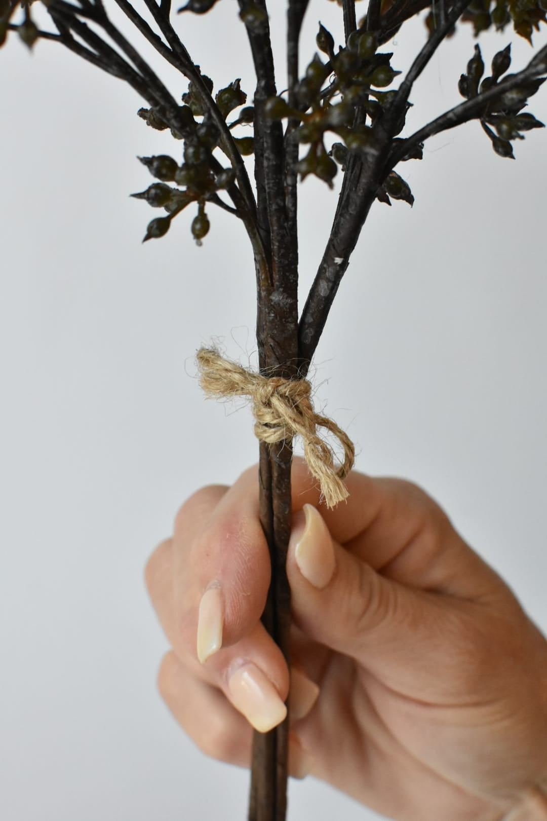 Three wired stems of faux dark brown and green sedum held together as one bundle