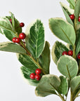 Close-up of red foam berries on a faux variegated holly stem
