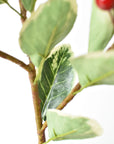 Faux variegated holly stem with red berries shown from a second angle