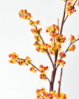 Wired faux bittersweet branch bent into a curved shape