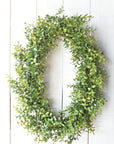 faux Variegated boxwood oval wreath on white board background