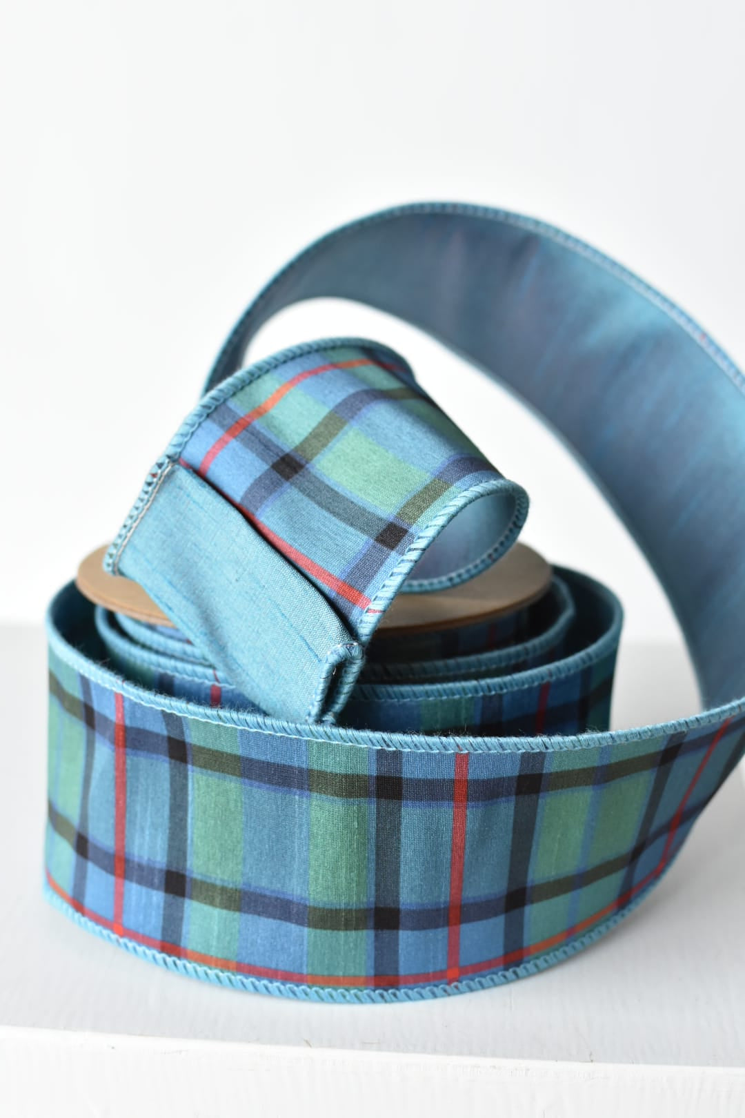 2.5 inch light blue plaid wired ribbon with a solid blue back
