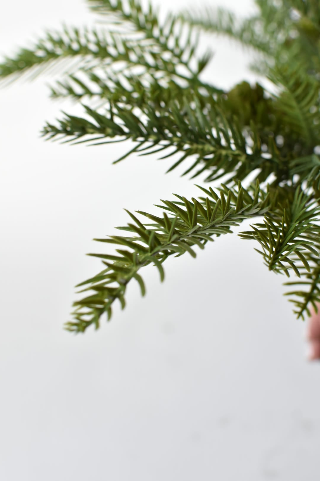Artificial pine branches with pine cones tucked into the greenery