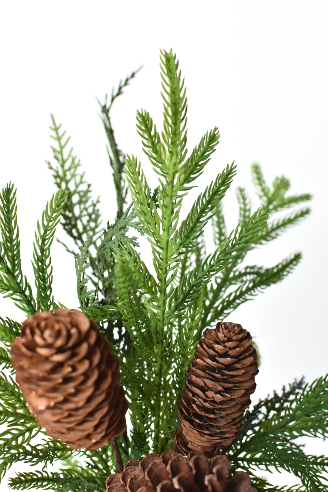 Real pine cones in mixed sizes tucked into artificial pine branches