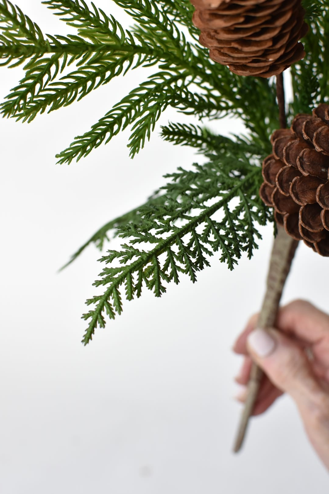 Artificial cedar and pine needles on a mixed winter greenery bush