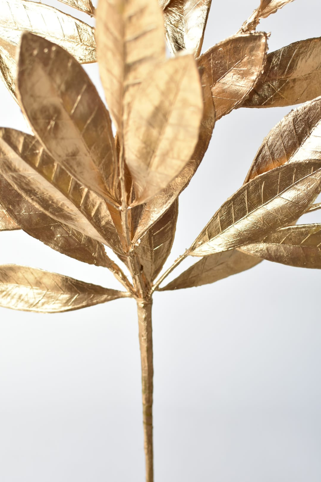 Metallic gold leaf stem made from molded plastic and wire for holiday decorating