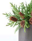 Three faux pine and cedar bushes styled together in a container