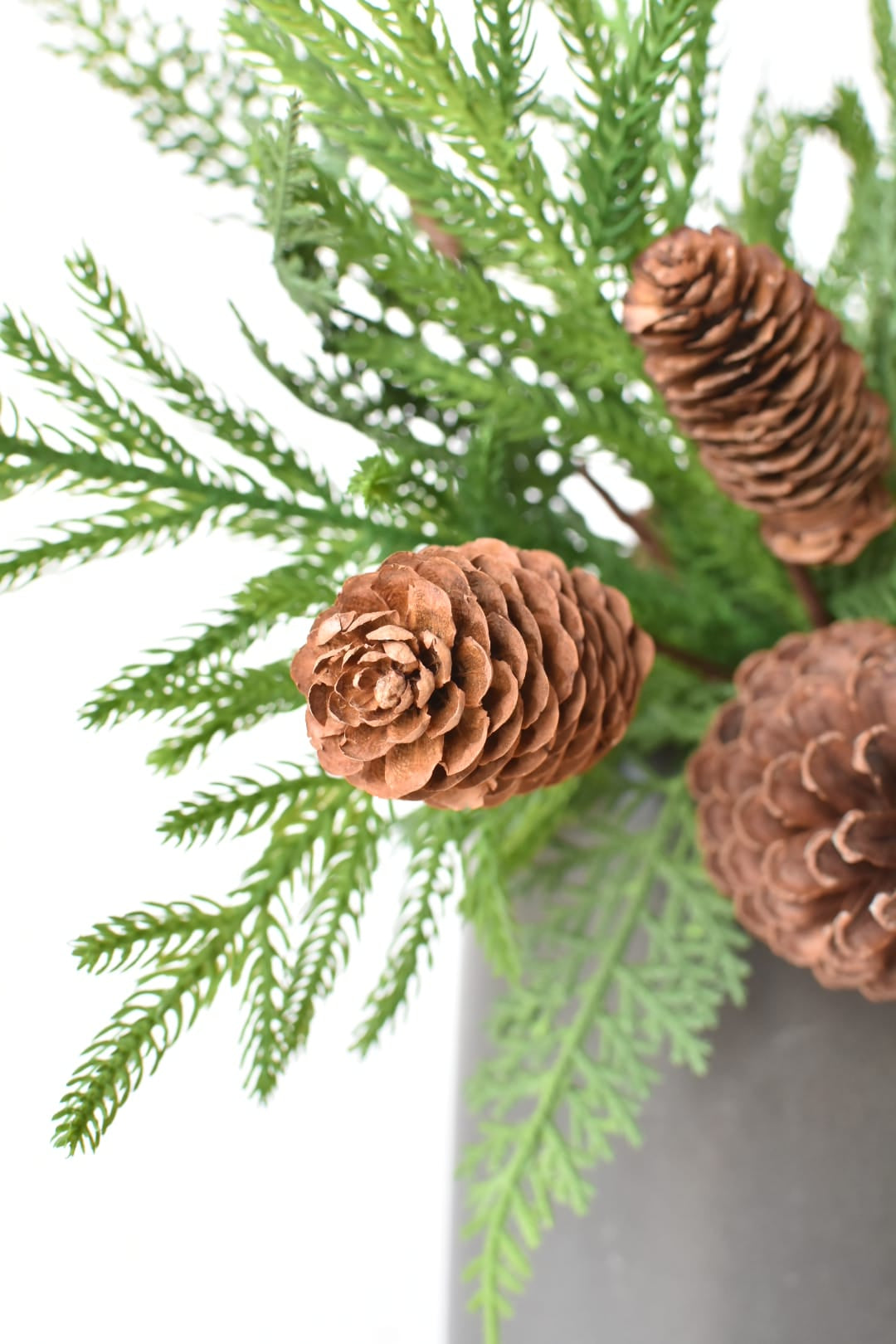 Close-up of mixed faux pine and cedar bushes filling a container