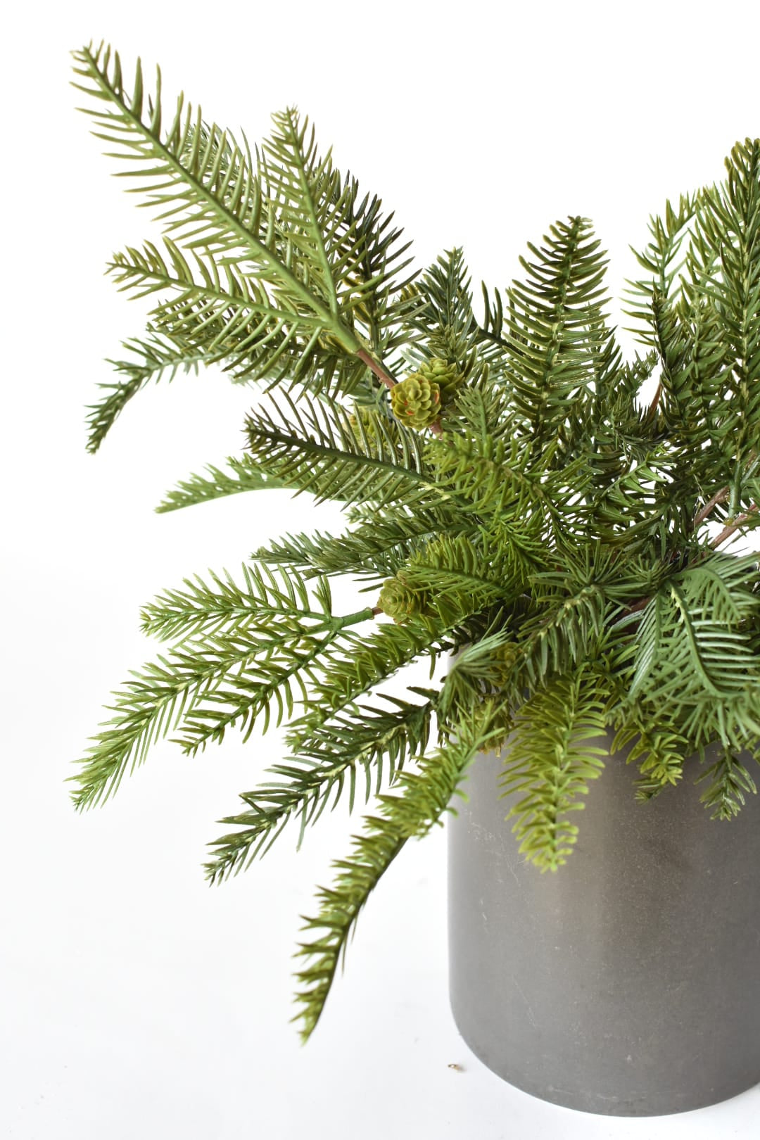 Pot filled with two artificial pine bushes for outdoor Christmas greenery