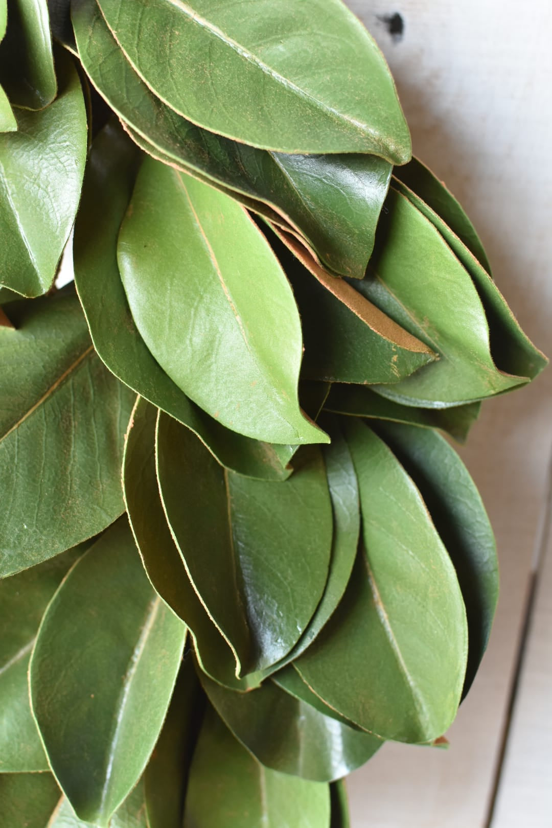 Faux magnolia leaf wreath at an angle showing depth and layered Real Touch leaves