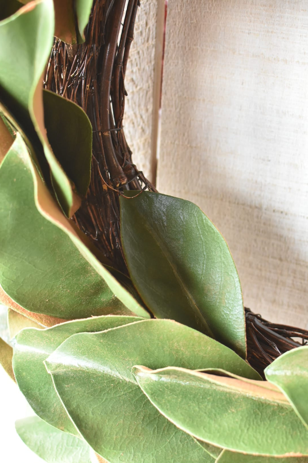 Two-tone green faux magnolia wreath detail showing new and established leaf growth