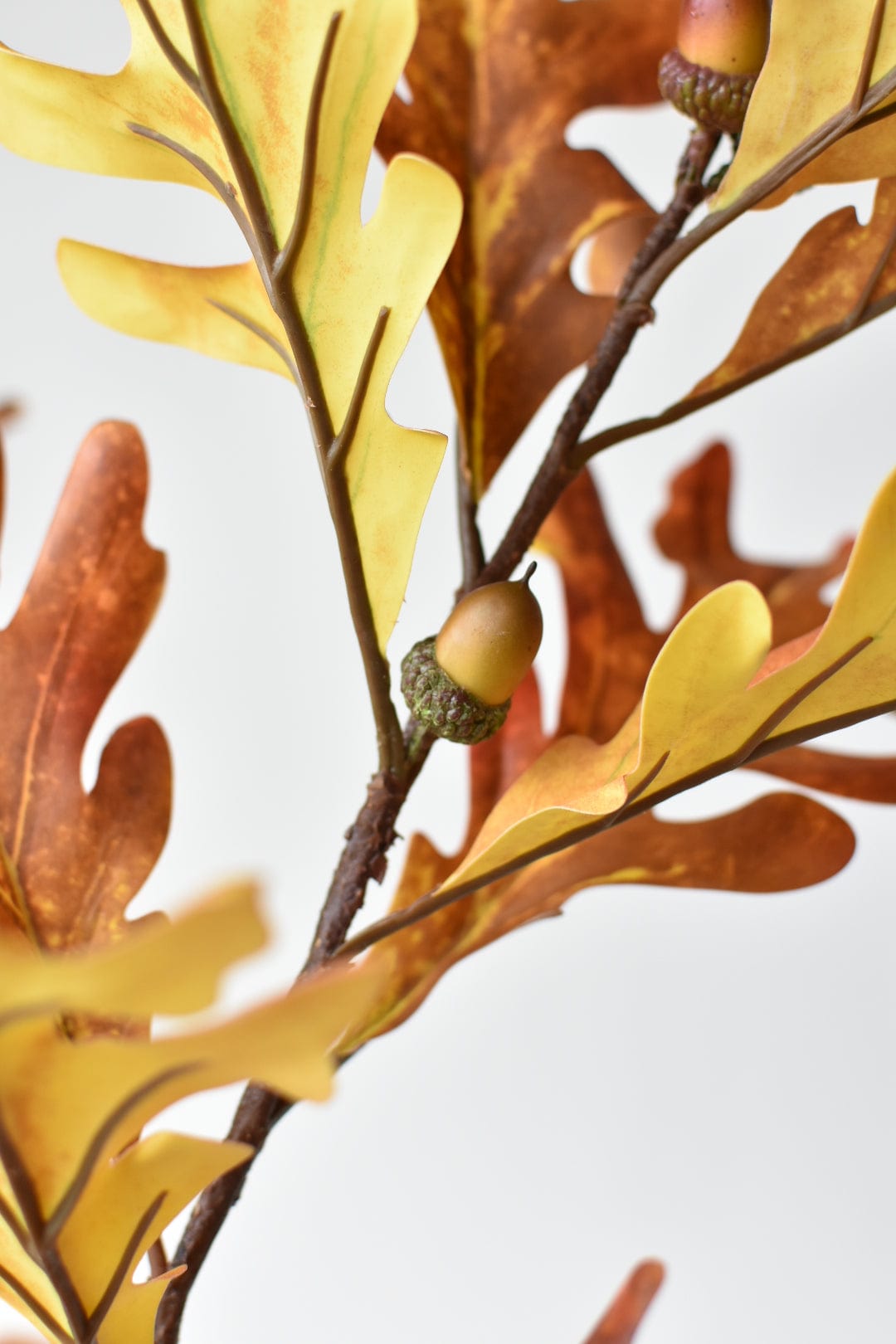 Close-up of orange and yellow faux oak leaves with acorns