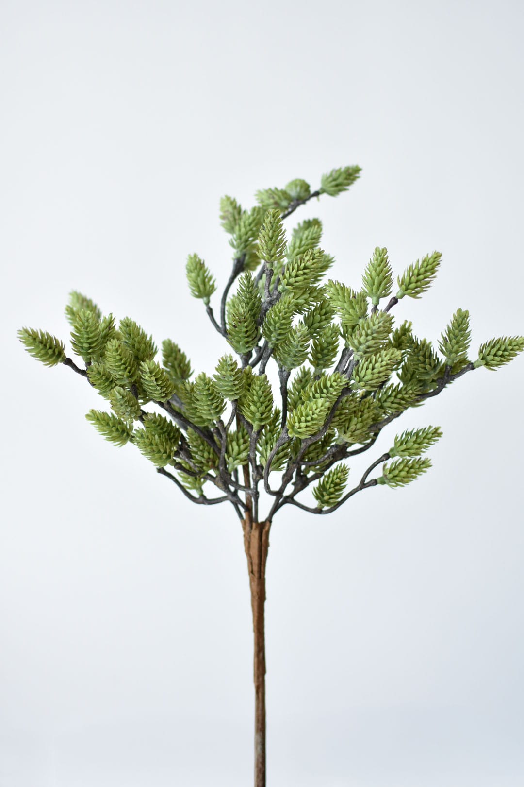 Green faux pinecones in detail showing the molded plastic color and cone texture